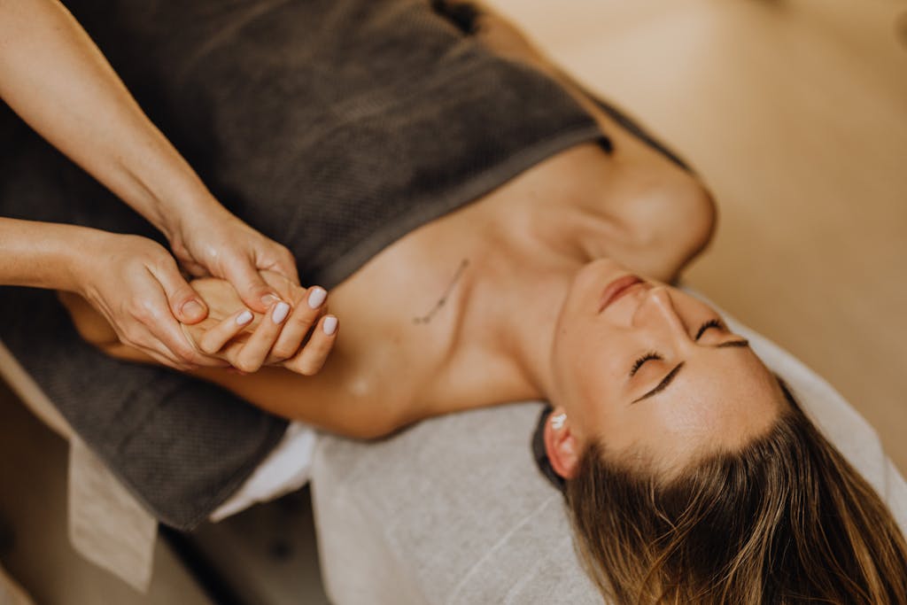 A woman enjoys a relaxing hand massage at a spa, promoting pampering and relaxation.